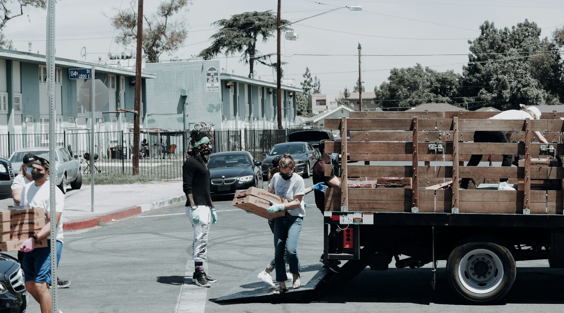 Volunteers unloading food boxes from a truck for neighborhood distribution