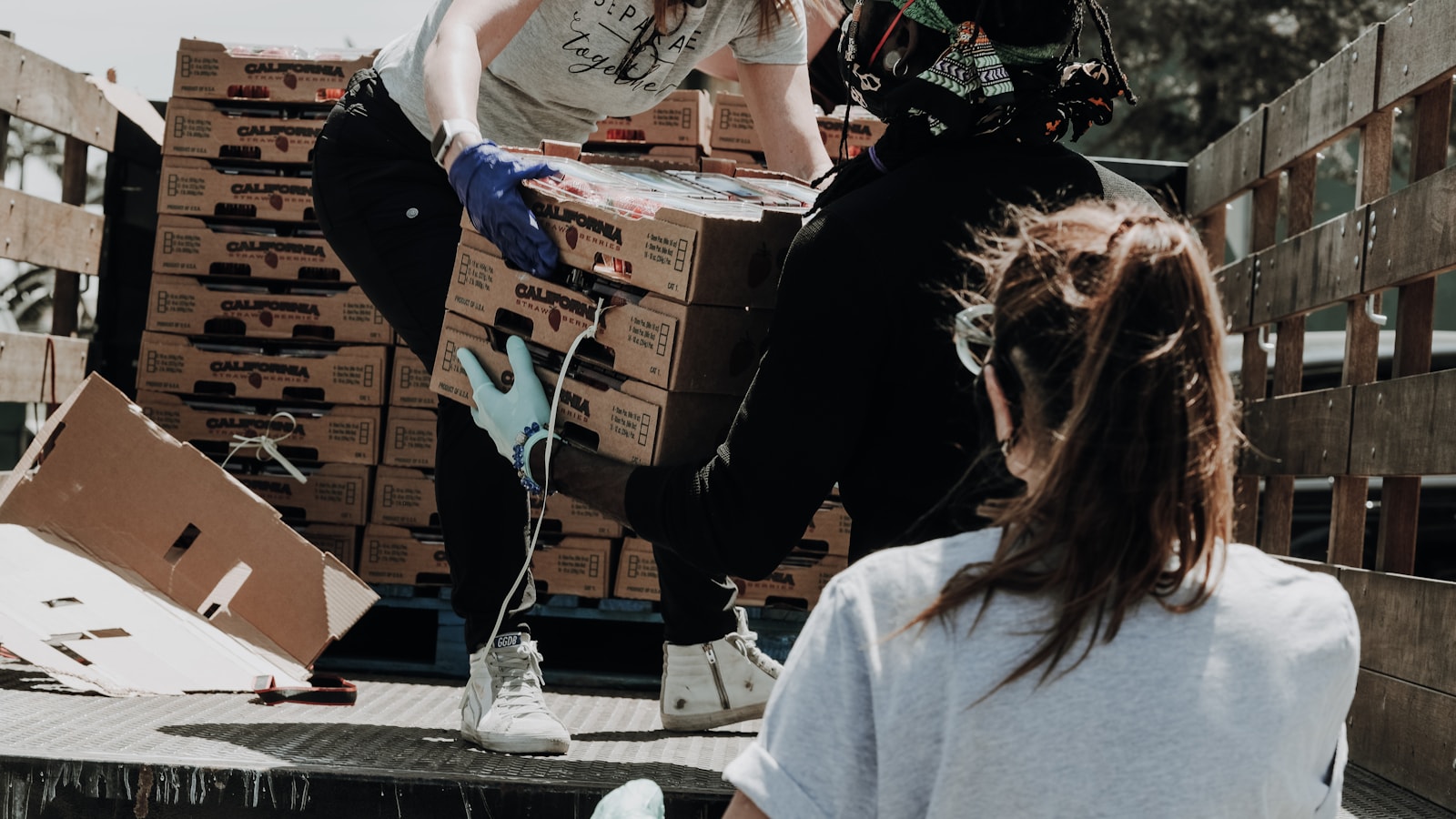 Volunteers unloading California produce crates from a truck bed